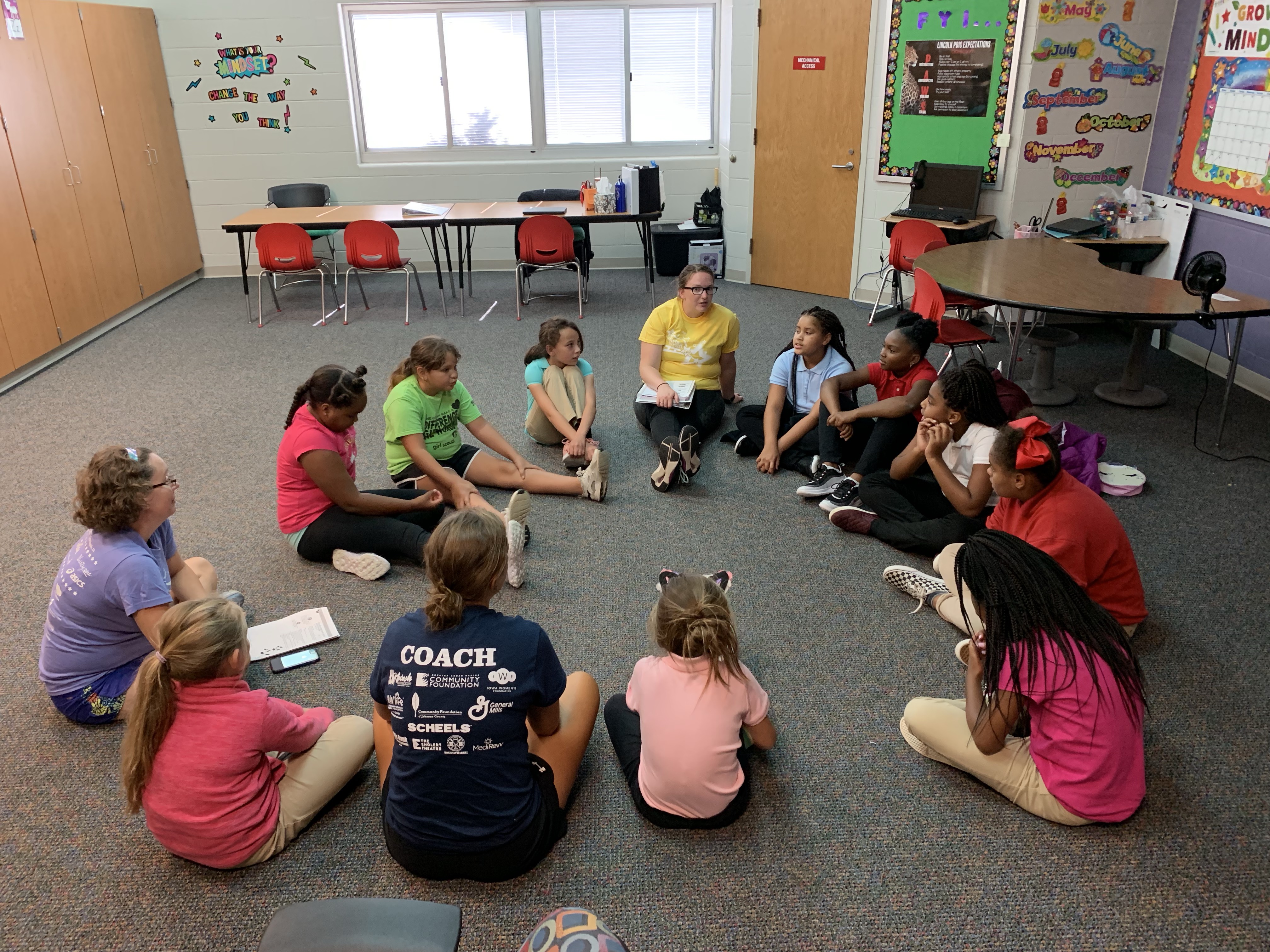 A group of girls sitting in a circle during Girls on the Run