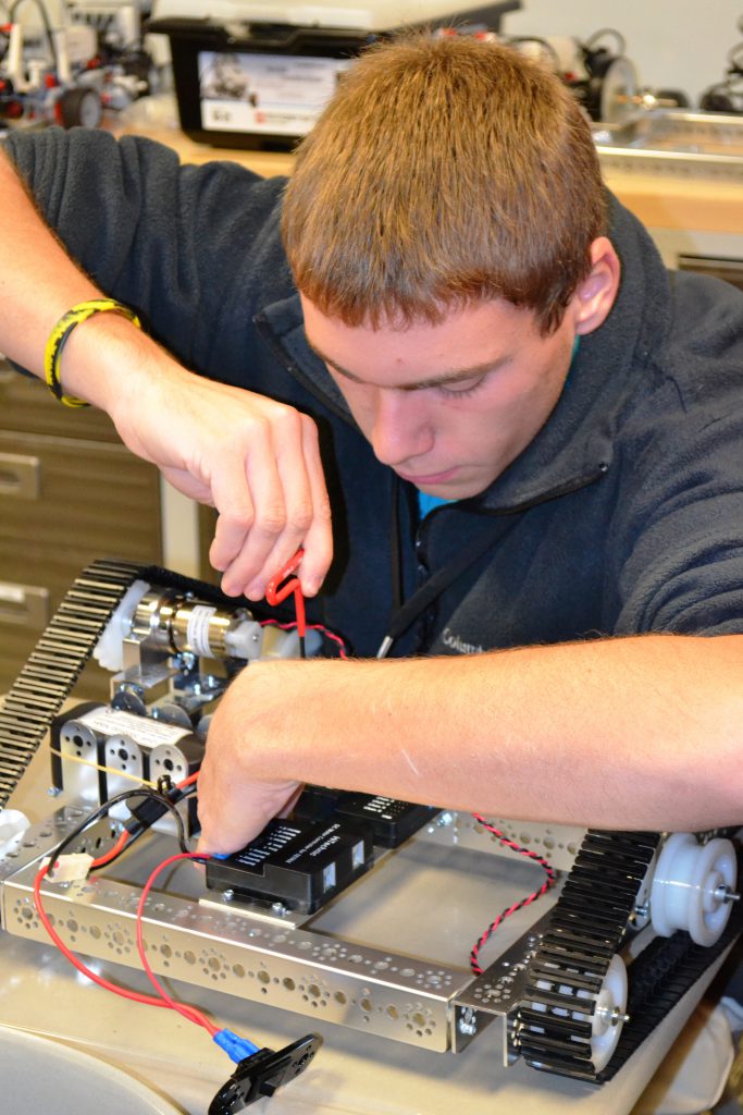 East High student working on a robot.