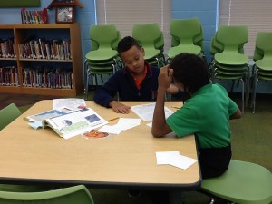 Two fourth grade students looking at an atlas