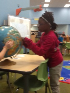 4th grade girl looking at globe