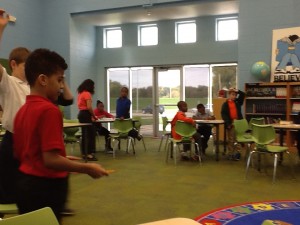 Class of 4th grade students meeting in groups at tables