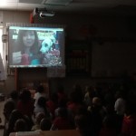 children looking at board during a skype session with a fire dog