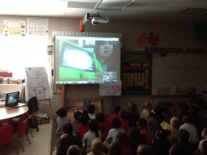 Kindergarten class looking at Molly the Fire Safety do who is on the Promethean Board