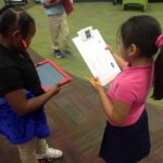 Two Students looking at clipboard during Media Class