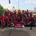 Lincoln Staff and Students smiling during parade with Lincoln Banner