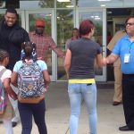 A family entering the school and high five greeters